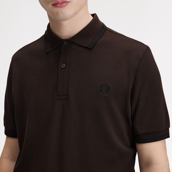 Model Wearing Fred Perry M3600 Mod Twin Tipped Polo Shirt in Rich Brown / Black - Chest Close Up