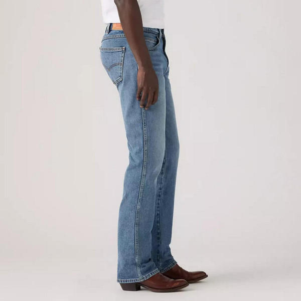 Model Wearing Levi's Men's 537 Western Bootcut Medium Wash Blue Denim Jeans in Throw The Lasso - Side