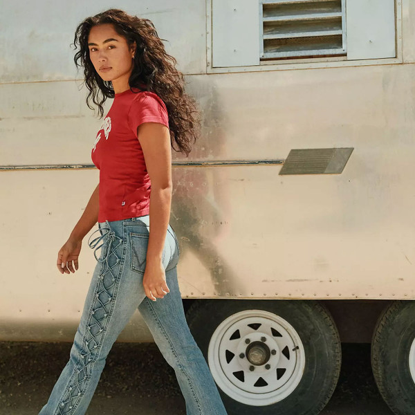Woman walking wearing Wrangler Women's Shrunken Band T-Shirt in Chili Pepper Red