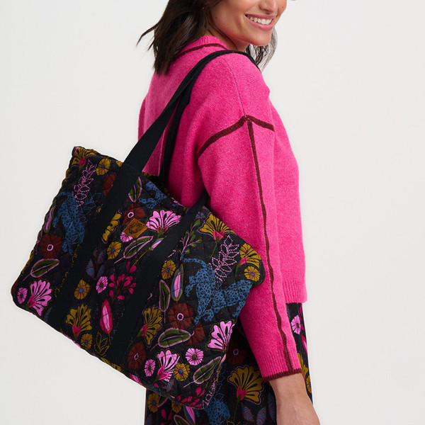 Woman carrying Sugarhill Brighton Haven Jungle Panther Quilted Tote Bag in Black on shoulder