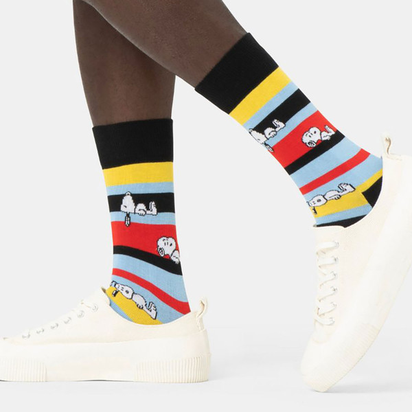Model wearing Happy Socks x Peanuts Snoopy Striped Socks in Black