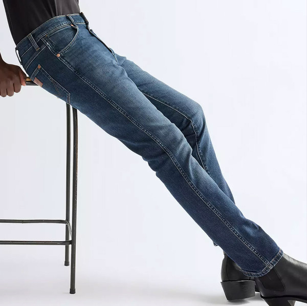 Man wearing Wrangler Larston Slim Tapered Low Stretch Blue Denim Jeans in Moonlit Blue