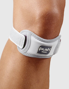 Push med patellar strap fitted on knee during stretch demonstrating stability and tendon pressure relief.