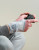 Push care wrist brace worn while using a game controller, supporting the wrist during repetitive hand and finger activity.