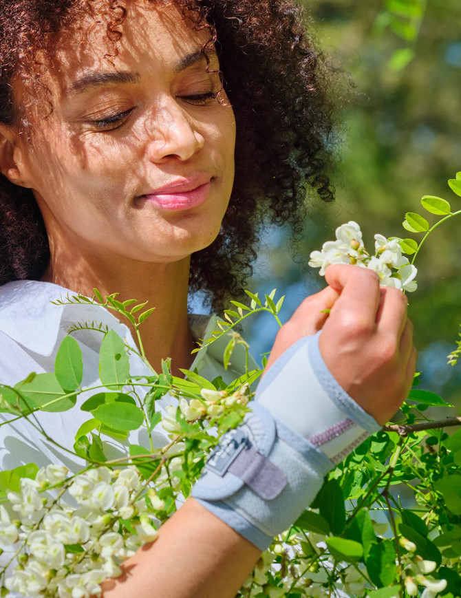 Push care wrist brace used outdoors during light gardening, providing comfortable wrist support for daily movements.