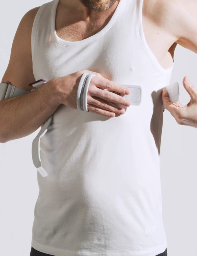 Close-up of Push med Shoulder Brace being fastened, showing soft Sympress™ material and secure fastening system for stable arm support.