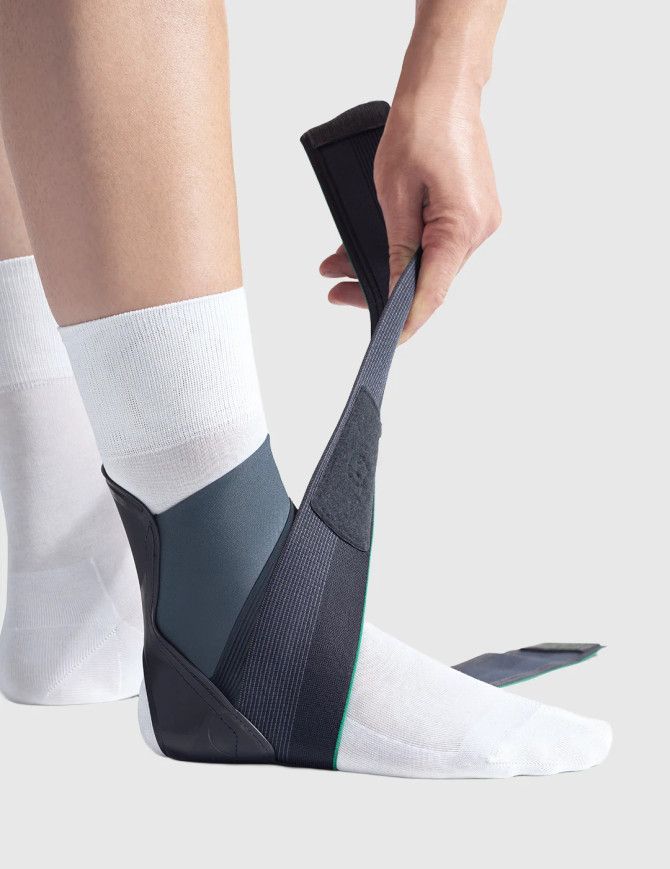 Close-up of Push med Aequi Flex ankle brace being applied, highlighting adjustable strap system and secure fit around the ankle.
