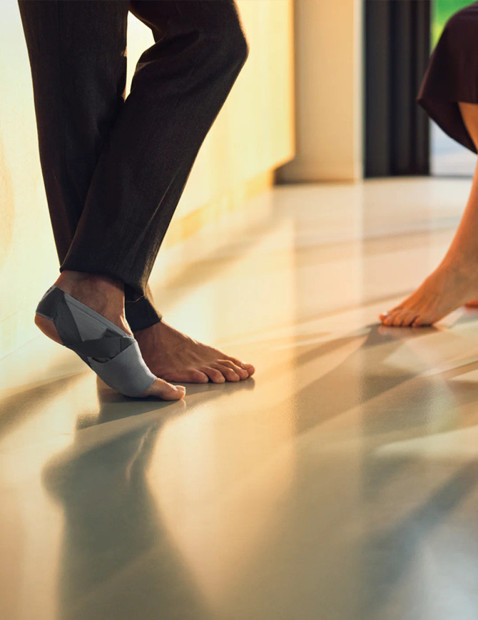 Lifestyle image of a person walking comfortably while wearing the Push med Foot Brace FP, supporting active management of plantar fasciitis during daily movement.