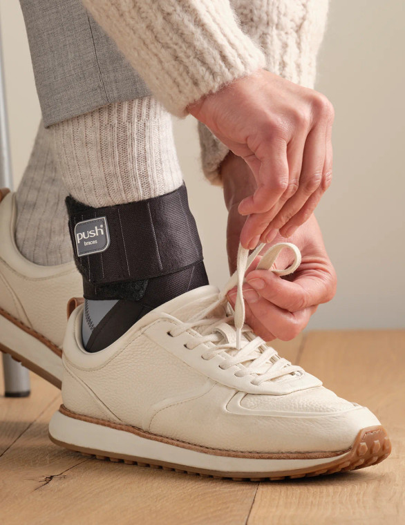 Push ortho ankle brace worn with everyday footwear, showing slim profile suitable for daily wear and rehabilitation use.