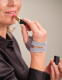 Push CMC thumb brace worn while applying lipstick, demonstrating functional hand use with thumb stabilisation.