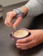 Push CMC thumb brace worn while holding a mug, illustrating support for everyday gripping tasks.