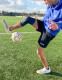 Athlete wearing Push Sports Knee Brace while performing soccer drills, providing controlled knee support during movement