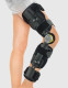 Side profile of the Conwell Medical length adjustable knee brace fitted on a leg, showing secure hook-and-loop straps and extended length support.