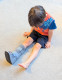 Child seated wearing paediatric walker boot, showing stability and protection for everyday movement.