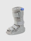 Product-only side view of paediatric walker boot showing adjustable straps, rigid support frame, and cushioned lining.
