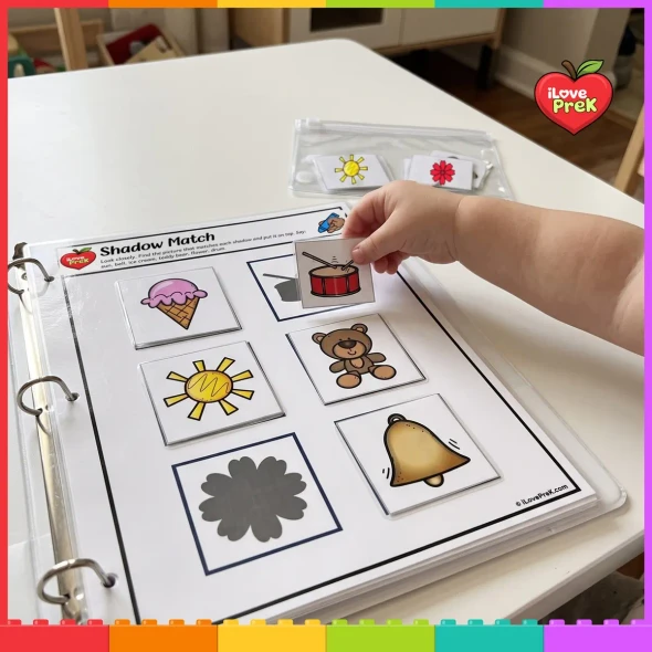 Toddler placing the drum card on its shadow in a busy binder.