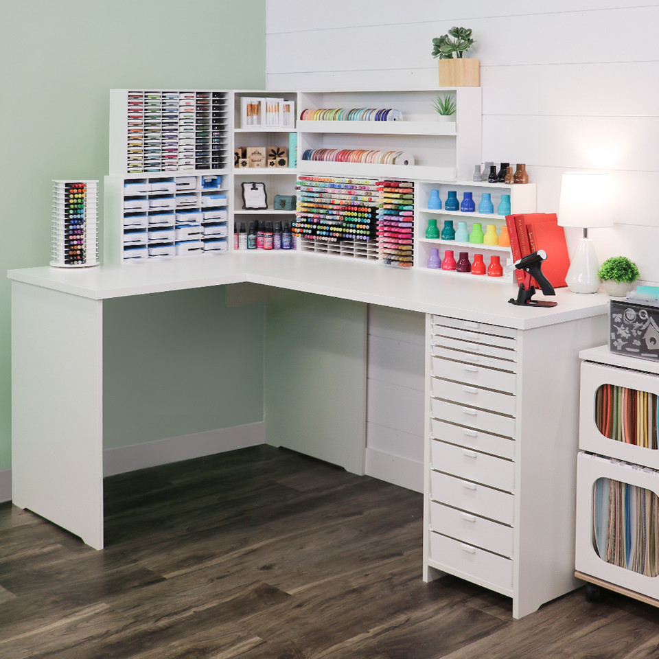 A coordinated craft desk with a clear work surface and integrated storage