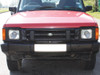 Britpart Radiator Muff for Discovery 1 V8 & 200Tdi, front view of red Land Rover Discovery 1 vehicle showing the radiator muff installed on the front grille.