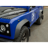 Britpart Front 30mm Wider Wheel Arch Pair for Defender, close-up view of a blue Land Rover Defender with gray wheel arches and off-road tires.