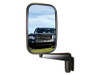Direct Replacement Door Wing Mirrors with Arms (Pair) - MTC5217 for Defender 90/110/130, side view of vehicle mirror reflecting a black Land Rover Defender 90/110/130 in a grassy outdoor setting.