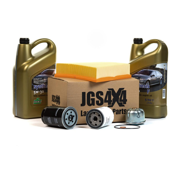 Product: Defender Td5 Engine Service Filter Kit & 5W30 ROCK Synthesis F Synthetic Oil, image shows two large bottles of synthetic engine oil, a filter kit including oil filters, a cardboard box, a yellow air filter, and various small parts arranged on a white background.