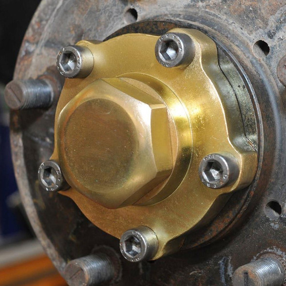 Britpart Heavy Duty Drive Flange Kit for Defender and Discovery 1, close-up of the gold-colored drive flange assembly attached to a rusty wheel hub with bolts.
