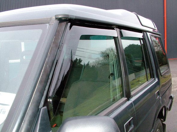 Britpart Window Wind Deflector Set for Discovery 1, car window wind deflector installed on a black vehicle's front and rear windows.
