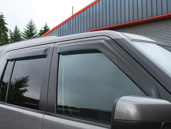 Britpart Window Wind Deflector Kit for Discovery 3 and 4, installed on a vehicle's front window, featuring a sleek black design and vented for airflow. Britpart Window Wind Deflector Kit for Discovery 3 and 4, installed on a vehicle's front window, featuring a sleek black design and vented for airflow.
