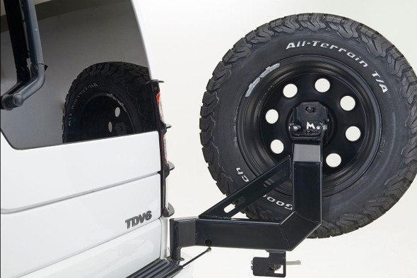 Terrafirma Swing Away Spare Wheel Carrier for Discovery 3 and Discovery 4, mounted on a white off-road vehicle, with a spare tire attached.