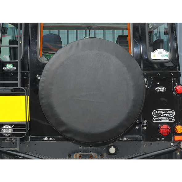 Britpart Plain Black Vinyl Spare Wheel Cover - DA2027, on the rear of a Land Rover Defender, protecting the spare wheel.