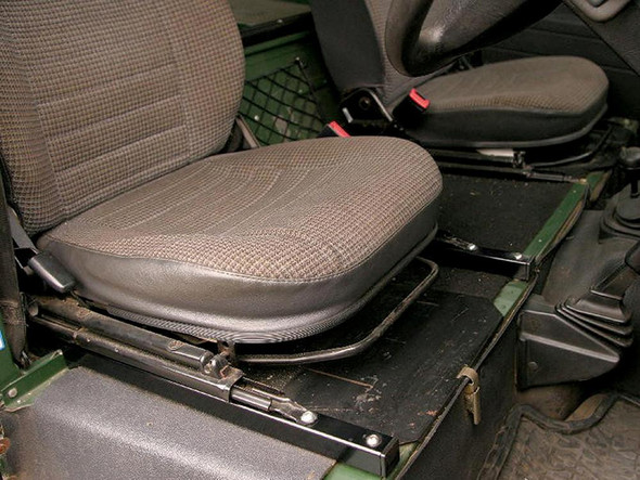 Britpart Seat Riser Raiser Rails for Enhanced Legroom for Defender, vehicle interior with elevated seat position, black metal rails installed under brown fabric seats.