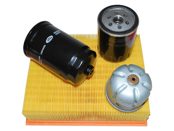 Genuine Land Rover Defender TD5 1998-2006 Engine Service Filter Kit, includes oil filter, fuel filter, and air filter, on a yellow pleated filter media, for Land Rover vehicle maintenance. Genuine Land Rover Defender TD5 1998-2006 Engine Service Filter Kit, includes oil filter, fuel filter, and air filter, on a yellow pleated filter media, for Land Rover vehicle maintenance.