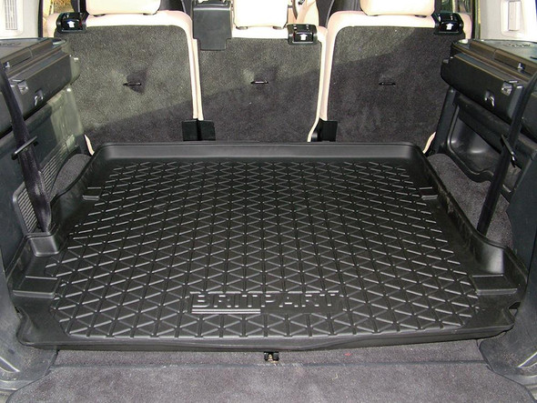 Britpart Premium Semi-Rigid Loadspace Boot Liner for Discovery 3, black rubber cargo liner fitted in the rear cargo area of an SUV with beige seats.