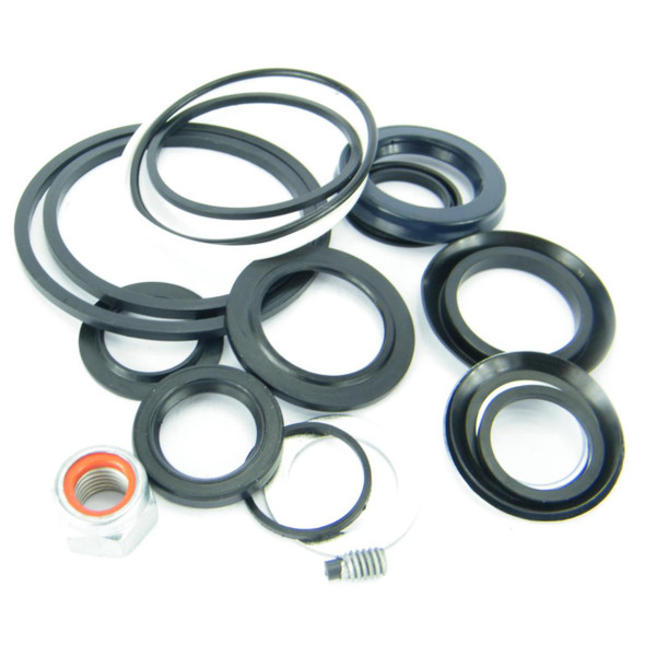 Direct Replacement Power Steering Box Seal Kit 4 Bolt, image showing a collection of black rubber seals, O-rings, and a small metal fitting used for repairing Land Rover Defender and Discovery 1 steering systems.