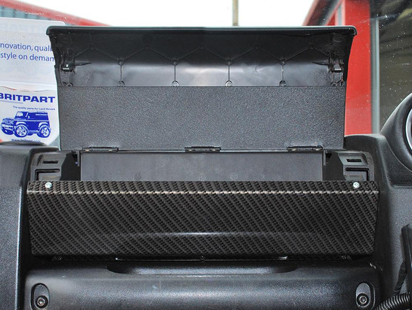 Britpart Glove Box Kit Carbon Fibre for Defender Puma, close-up of a carbon fibre glove box installed inside a vehicle's dashboard.