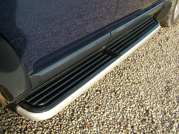 Direct Replacement Side Steps with OE Style Brushed Aluminium Trim (Pair) for Discovery 3/4, close-up of alloy side steps with black textured surfaces and Brush Aluminium accents on a gravel surface.