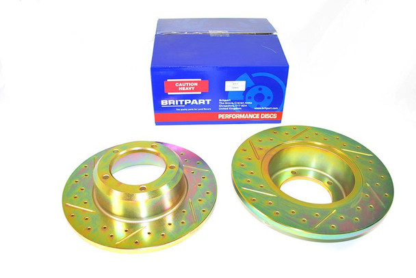 Britpart Front Solid Brake Discs Drilled and Grooved Performance Upgrade for Discovery 1, showcasing two gold-coloured brake discs with drilled and grooved surfaces and a blue Britpart box in the background. Britpart Front Solid Brake Discs Drilled and Grooved Performance Upgrade for Discovery 1, showcasing two gold-coloured brake discs with drilled and grooved surfaces and a blue Britpart box in the background.