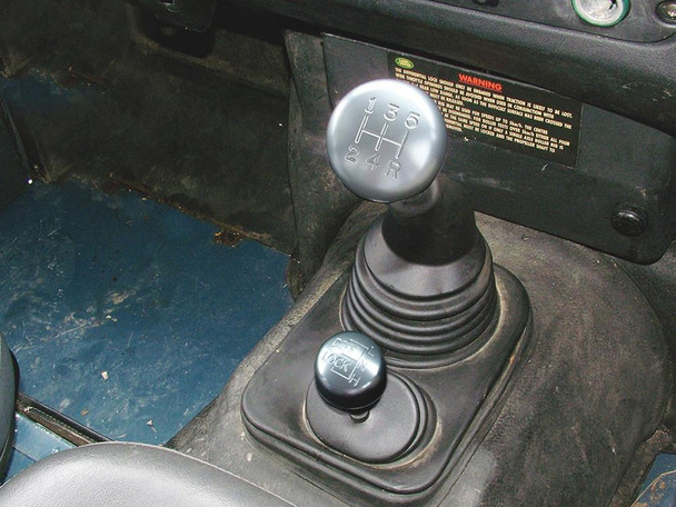 Britpart Alloy Gear Lever Knob Set LT77 for Defender, silver gear shift knob on a manual transmission in a vehicle interior. Britpart Alloy Gear Lever Knob Set LT77 for Defender, silver gear shift knob on a manual transmission in a vehicle interior.