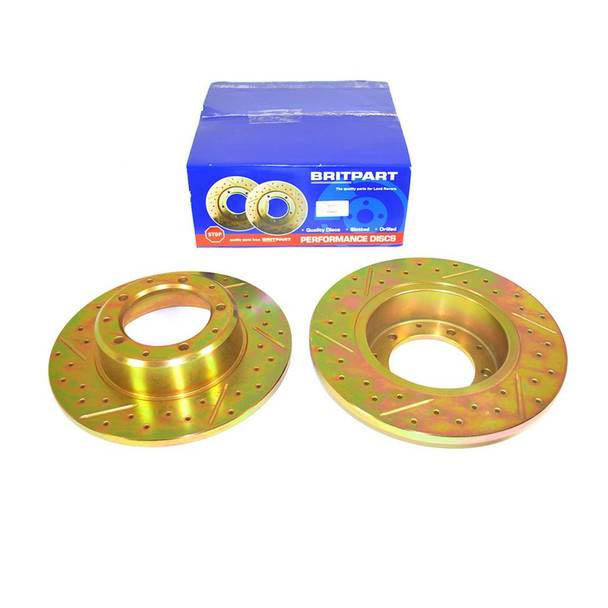 Britpart Rear Brake Discs Solid Drilled and Grooved Performance Upgrade for Defender, yellow gold colour, with packaging box in the background.