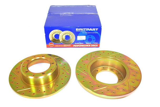 Britpart Rear Brake Discs Solid Drilled and Grooved Performance Upgrade for Defender, yellow gold colour, with packaging box in the background.