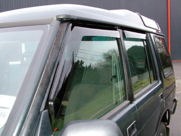 Britpart Window Wind Deflector Set for Discovery 1, car window wind deflector installed on a black vehicle's front and rear windows.