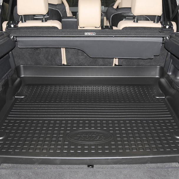 Genuine Land Rover Semi-Rigid Loadspace Protector for Discovery 3/4, black rubber cargo mat installed in the trunk of a Land Rover Discovery SUV.