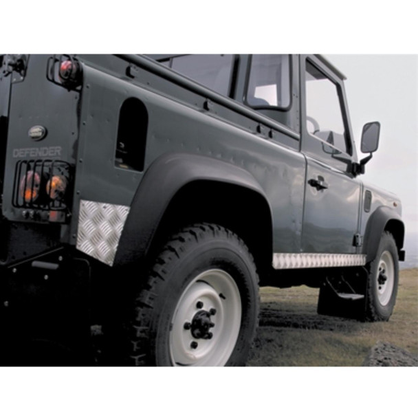 Britpart Chequer Plate Sill Protectors Silver Aluminium for Defender 90, close-up view of the side of a rugged green Land Rover Defender 90 with silver chequer plate sill protectors on the lower side.