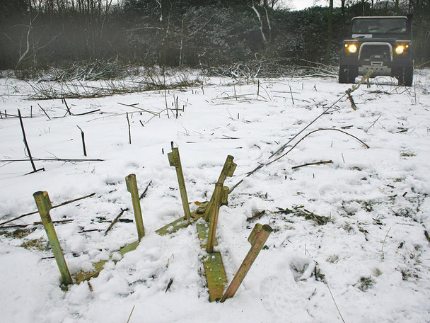 Britpart Heavy-Duty Winch Ground Anchor Kit, snow-covered ground with a ground anchor kit and a vehicle in the background. Britpart Heavy-Duty Winch Ground Anchor Kit, snow-covered ground with a ground anchor kit and a vehicle in the background.