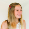 Big girls love our french clip barrettes, shown on a young lady in red