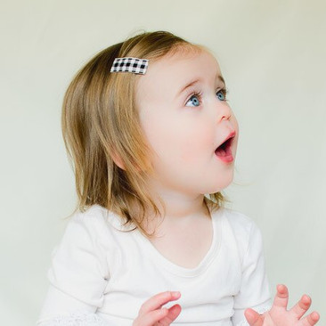 Ivory plaid toddler hair clips shown on a 2 year old