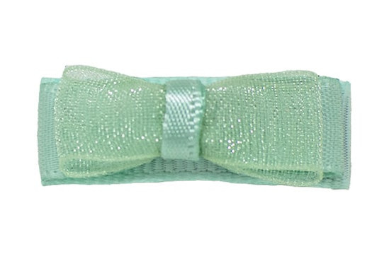 Intricately crafted newborn hair bow made with satin and organza, shown in pastel green on a bitty clip