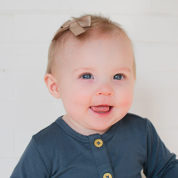 Our Carly hand-tied bow shown on a fine haired 8 month old is super cute and stays due to our magical bitty clip