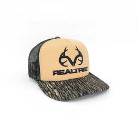 Angled front-right view of the foam trucker hat showing the tan logo panel and camo bill.