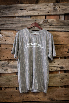 40th Anniversary Realtree Original camo tri-blend short sleeve shirt hanging on wooden backdrop with “America’s Most Versatile Camo Pattern” graphic main
